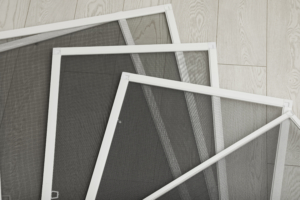 Set of window screens on wooden floor, flat lay